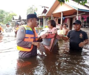 Berjibaku di Tengah Banjir, Bhabinkamtibmas Desa Kalahien Sigap Bantu Warganya