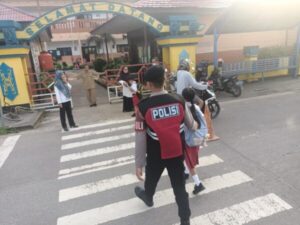 Jaga Keselamaran, Satsamapta Polres Lamandau Bantu Anak Sekolah Seberangi Jalan