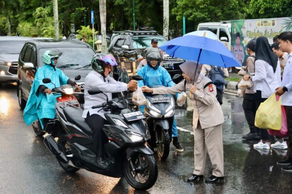 Ditengah Guyuran Hujan, Personel Polda Kalteng Tetap Semangat Bagi Takjil