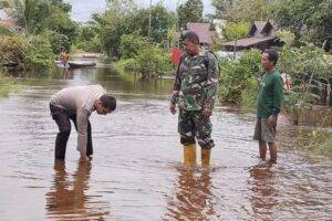 Tanggap Banjir, Bhabinkamtibmas Tumbang Tahai Meninjau Lokasi Luapan DAS Rungan