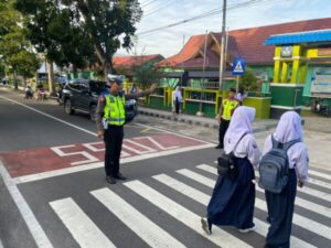 Satlantas Polres Sukamara Jaga Keselamatan Siswa yang Menyeberang Jalan