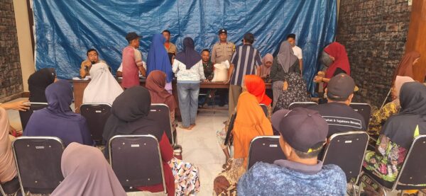 Anggota Polsek Rogojampi Amankan Penyaluran Bansos Dari Badan Pangan Nasional