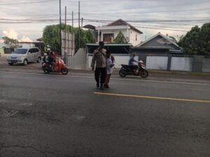 Beri Rasa Aman, Polisi Bantu Anak Sekolah Menyeberang Jalan