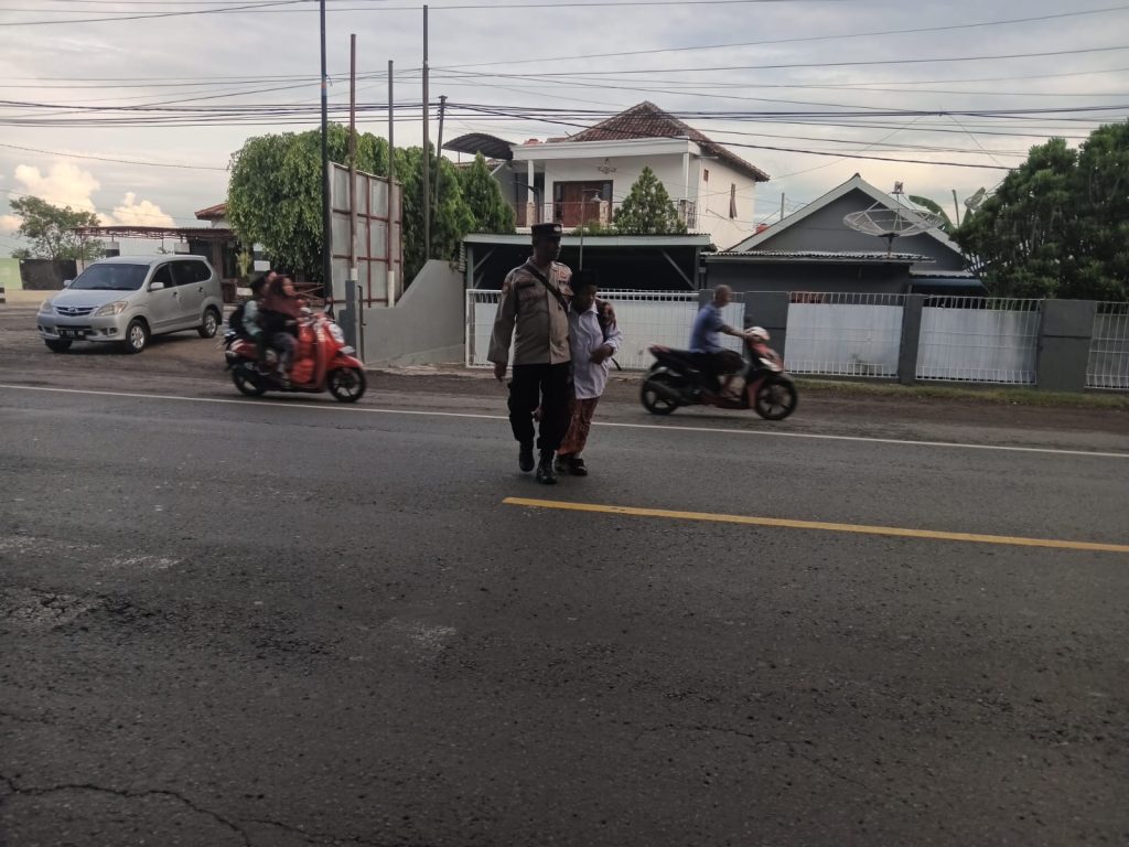 Beri Rasa Aman, Polisi Bantu Anak Sekolah Menyeberang Jalan