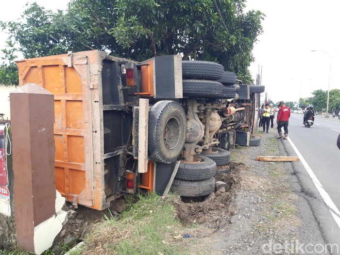 Ganti Ban Berujung Petaka, Truk Fuso Terguling Timpa Pagar Di